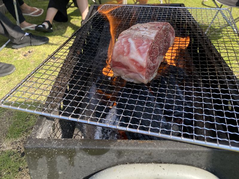 炭火の網の上で、大きなかたまり肉を焼いているところ