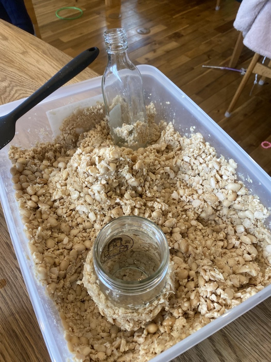 大きな容器で大豆をつぶして混ぜているところ